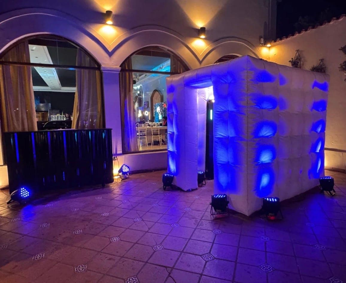 Cabina de fotos iluminada en azul dentro de un salón de eventos