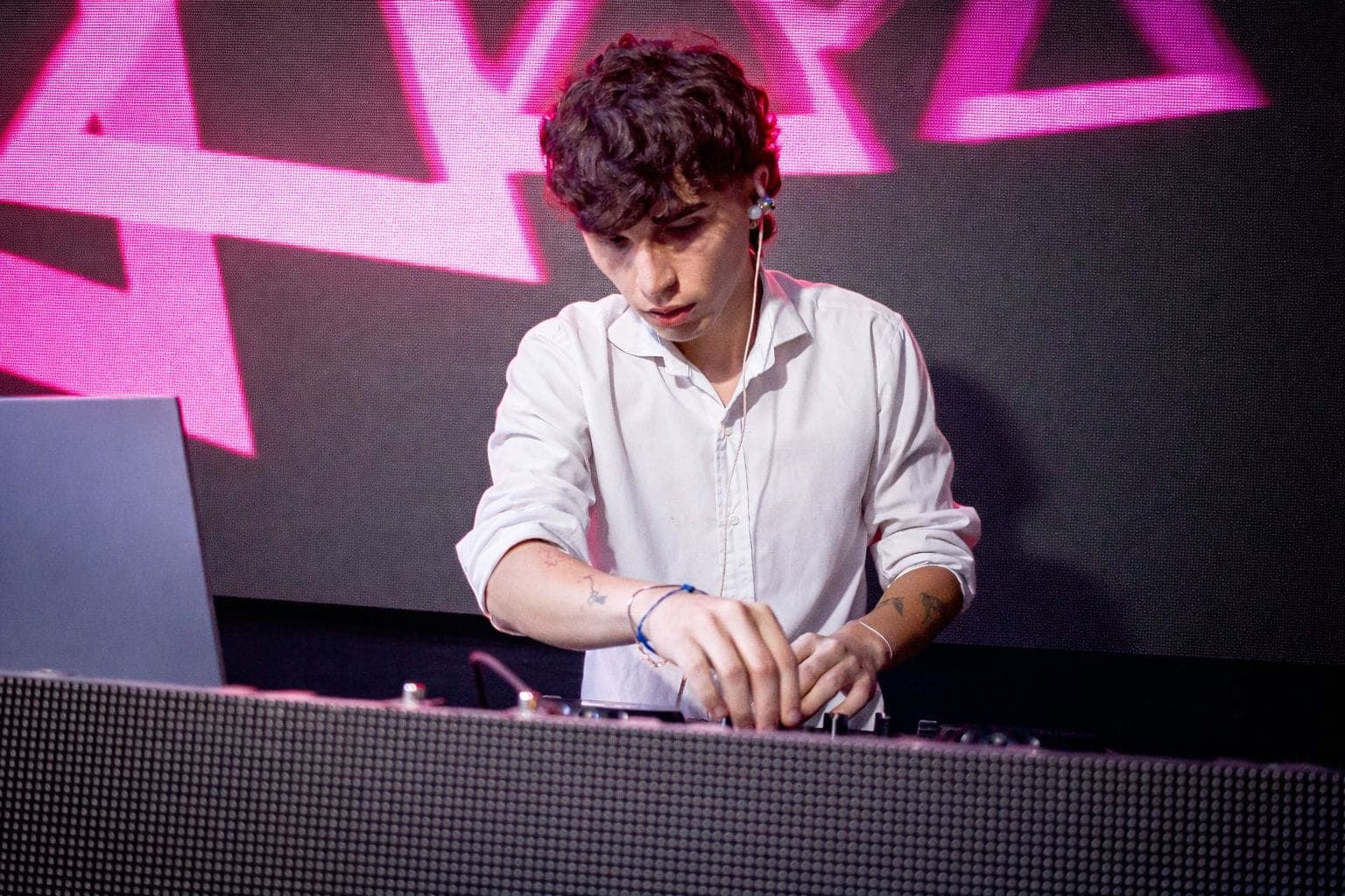 DJ mezclando en vivo frente a una pantalla LED